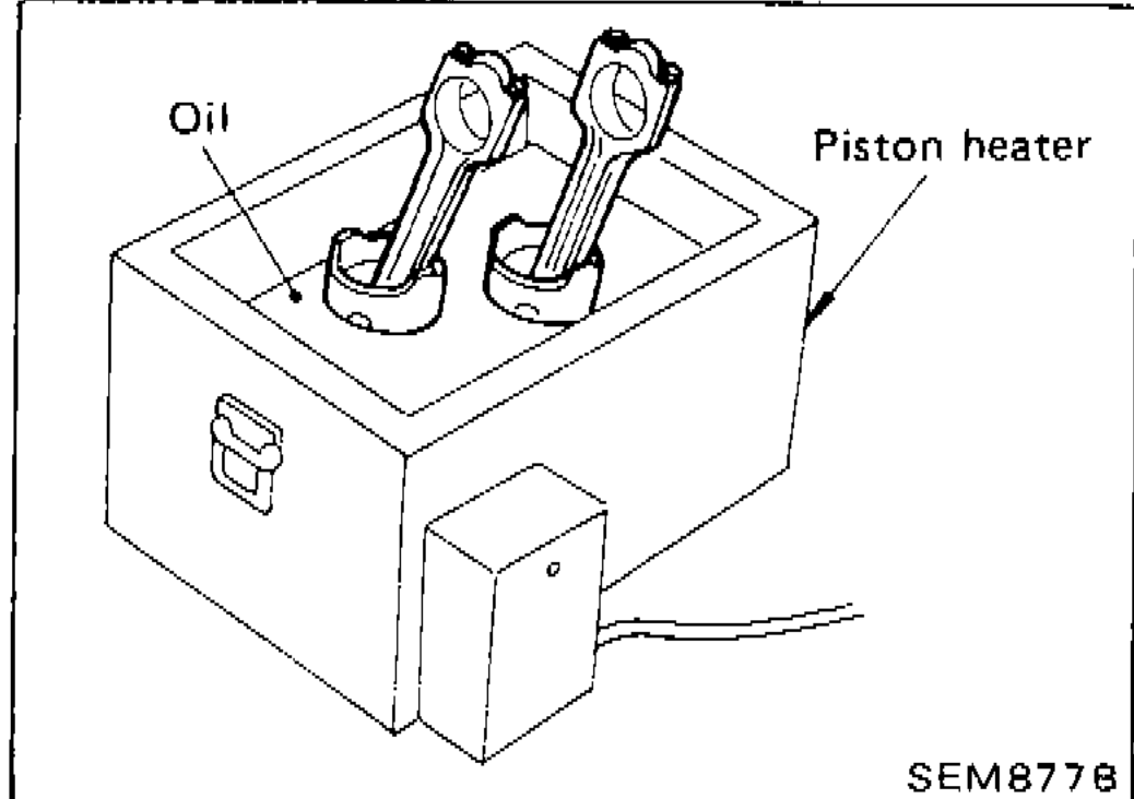 Piston heater oil bath being used to heat piston for disassembly from connecting rod