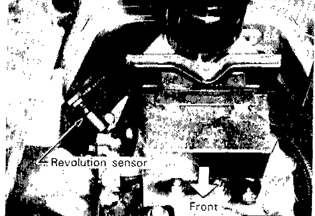 Photograph showing revolution sensor location on A/T assembly with front direction indicated