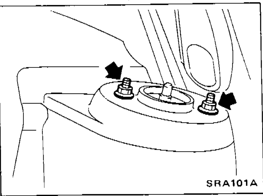 Close-up view of shock absorber upper end nuts with arrows indicating removal points