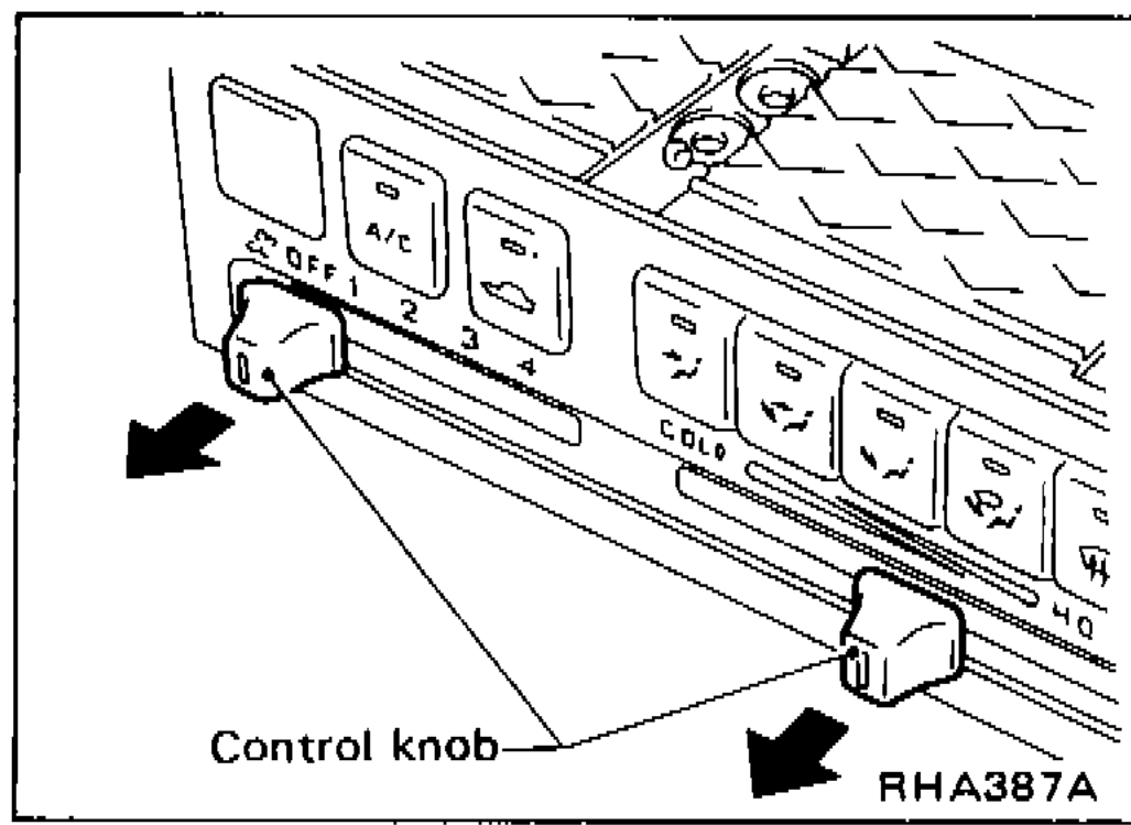 Two control knobs being pulled off the front of the push control assembly with cloth-wrapped pliers; arrow shows pull direction.